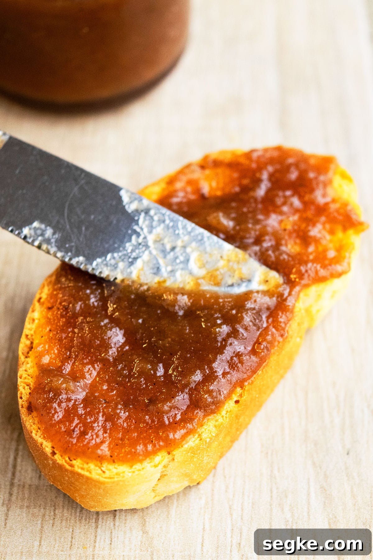 Using a Knife to Spread Flavored Butter on Slice of Bread.