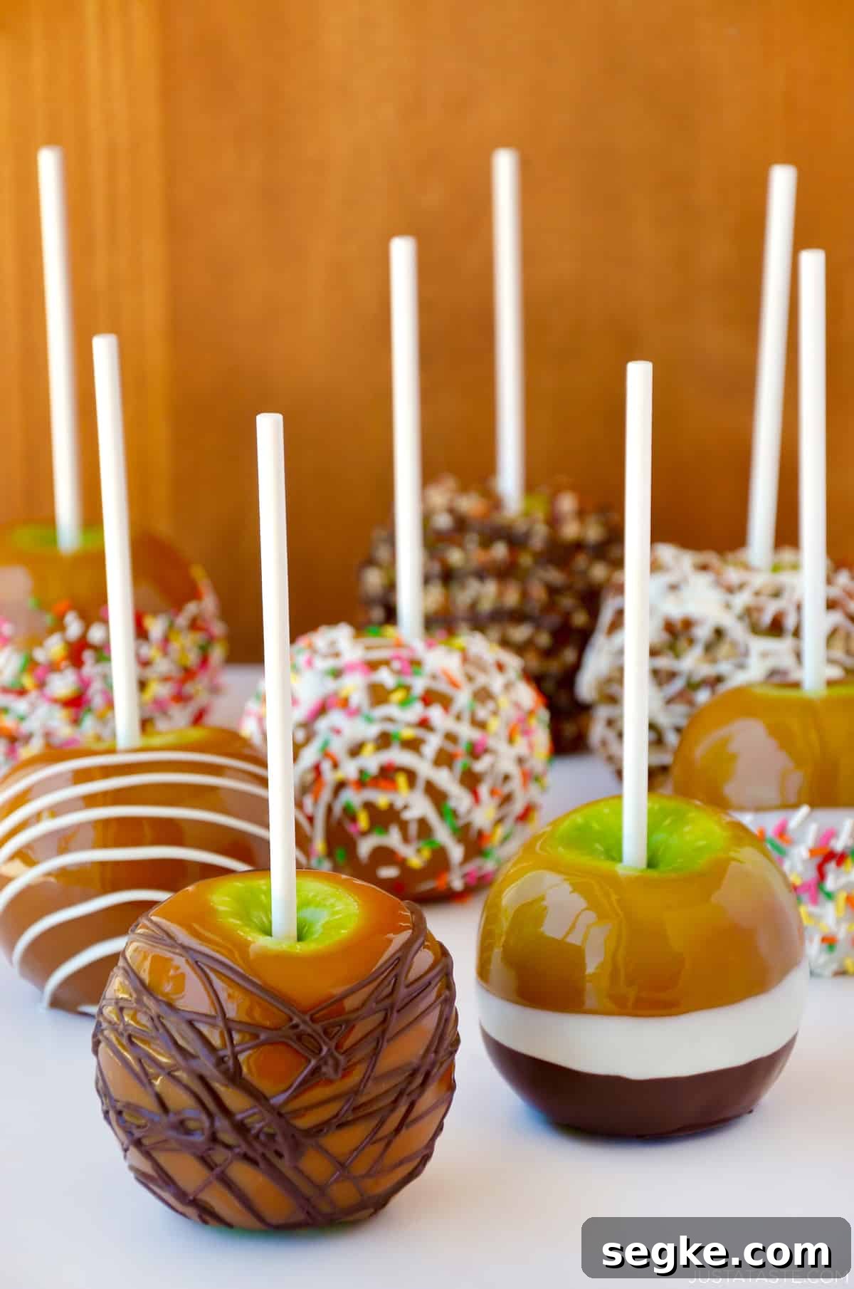 Spooky Halloween Dessert Recipes to Impress Guests 13 Caramel apples decorated with different toppings, including drizzled with milk chocolate, chopped walnuts, rainbow sprinkles and white chocolate.