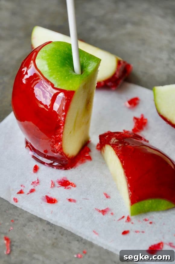 Spooky Halloween Dessert Recipes to Impress Guests 14 A green candy apple sliced on a grey baking sheet