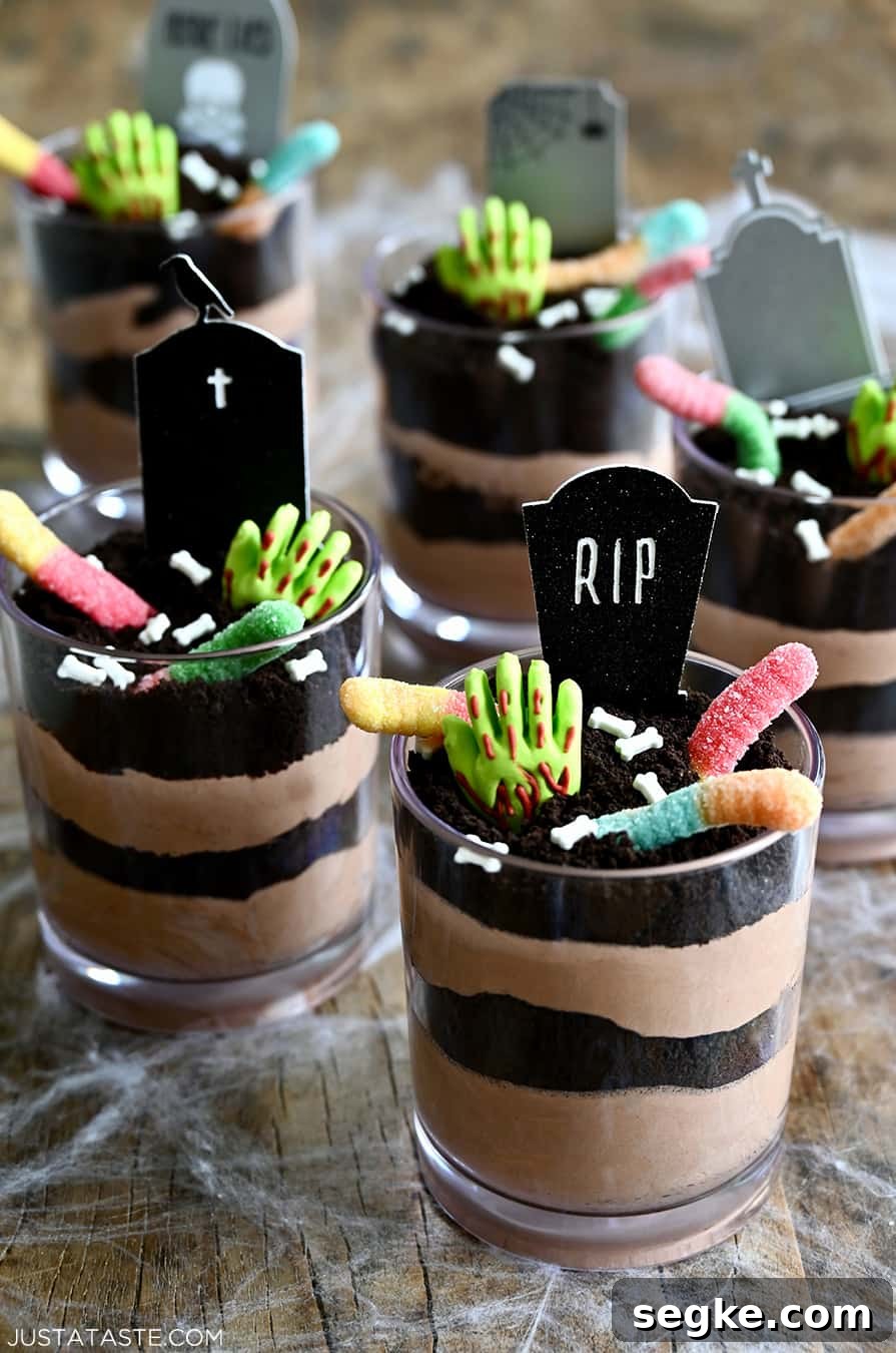Spooky Halloween Dessert Recipes to Impress Guests 7 Individual Halloween Dirt Cups with gummy worms, bloody gummy hands and RIP cake toppers