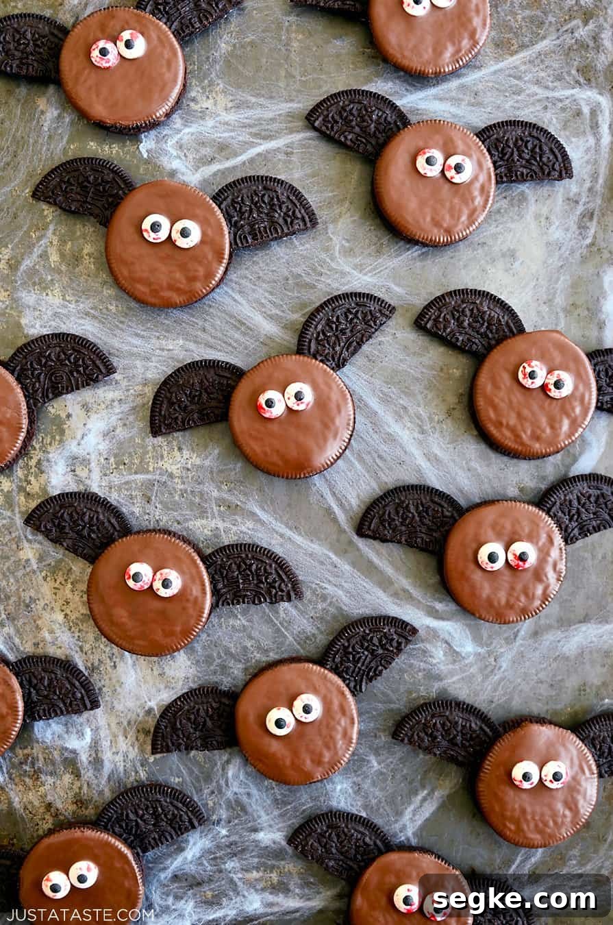 Spooky Halloween Dessert Recipes to Impress Guests 8 A top-down view of No-Bake Oreo Bat Cookies with bloodshot candy eyes atop fake cobwebs