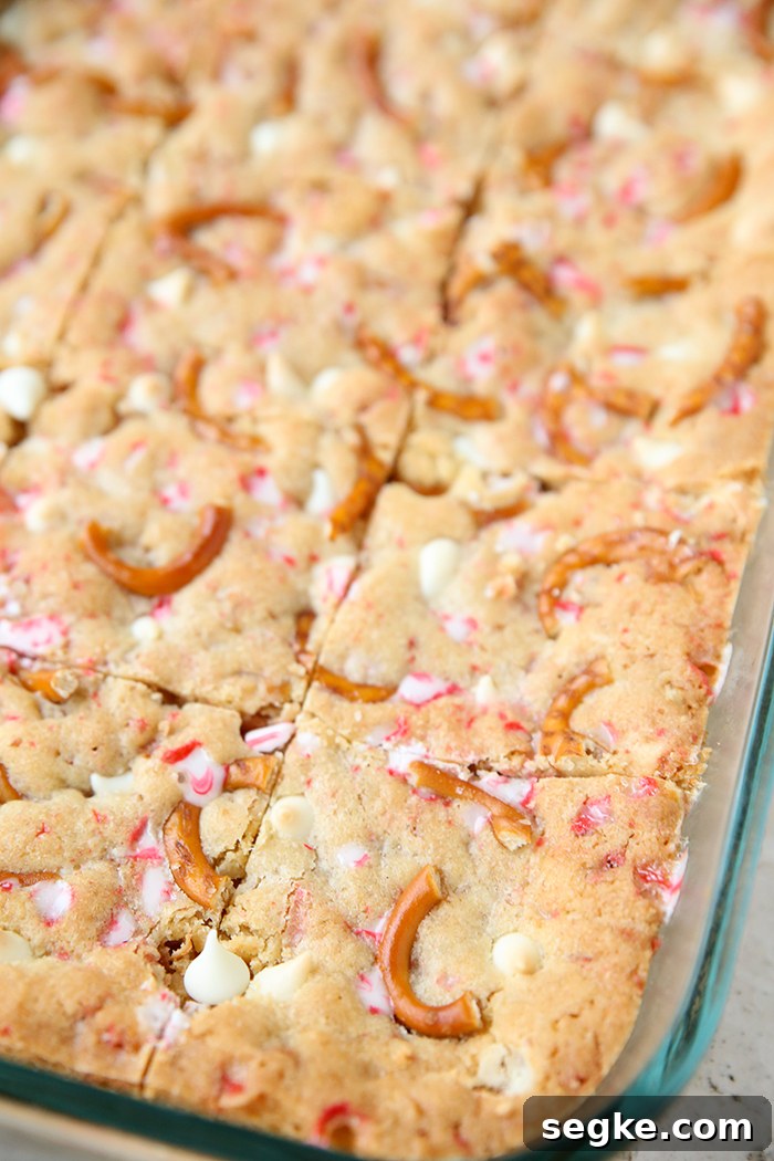 A partial picture of a glass 9x13 dish with cut white chocolate peppermint pretzel cookie bars.