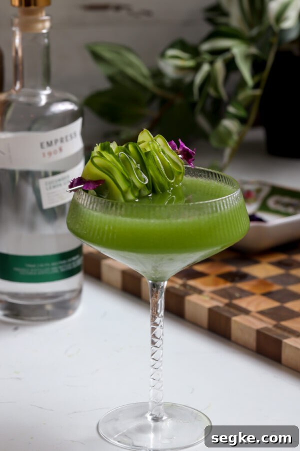 Cucumber martini made gin but you can make it with vodka, garnished with edible flowers and sliced cucumber.