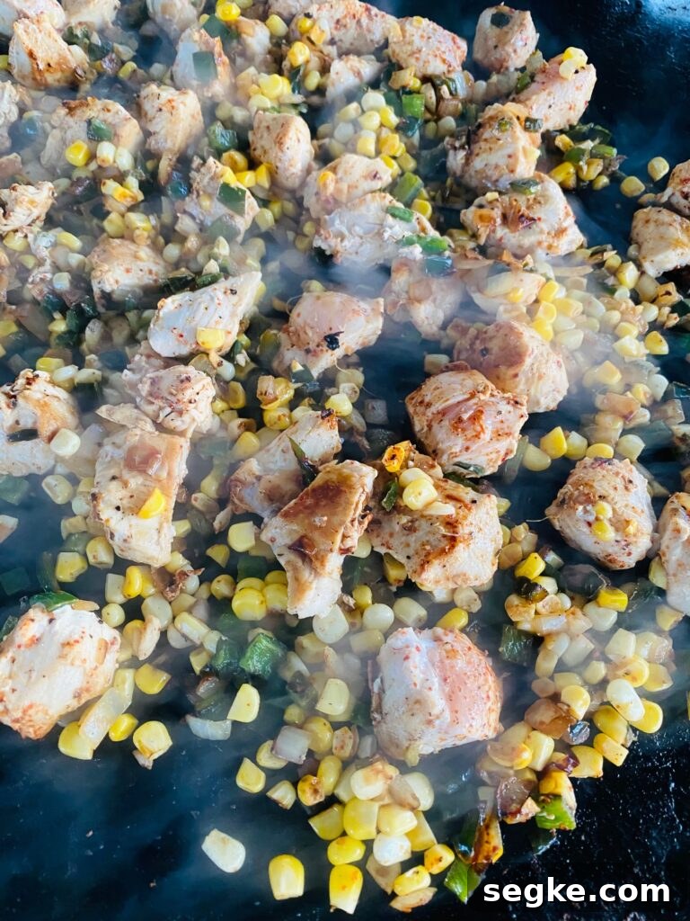 chicken and veggies cooking on the griddle