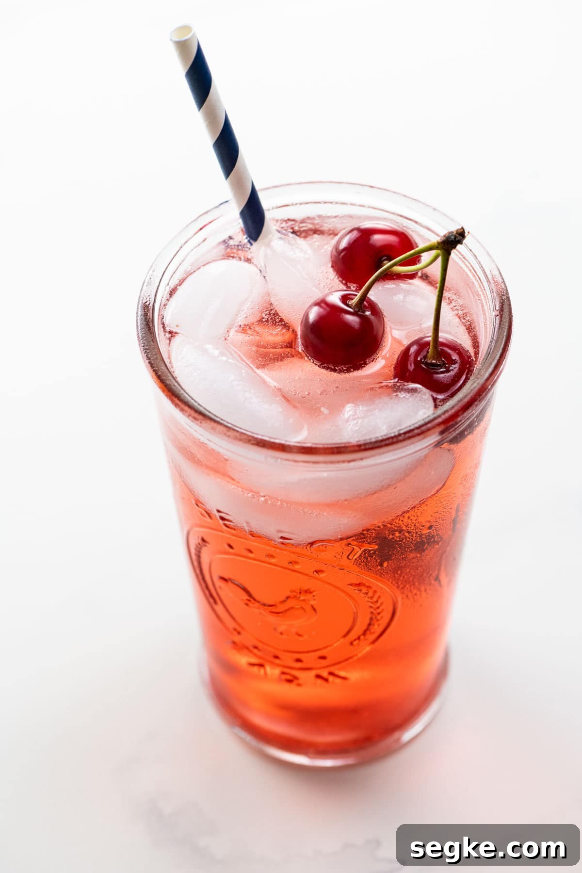 shirley temple recipe with sour cherries in a glass with a straw