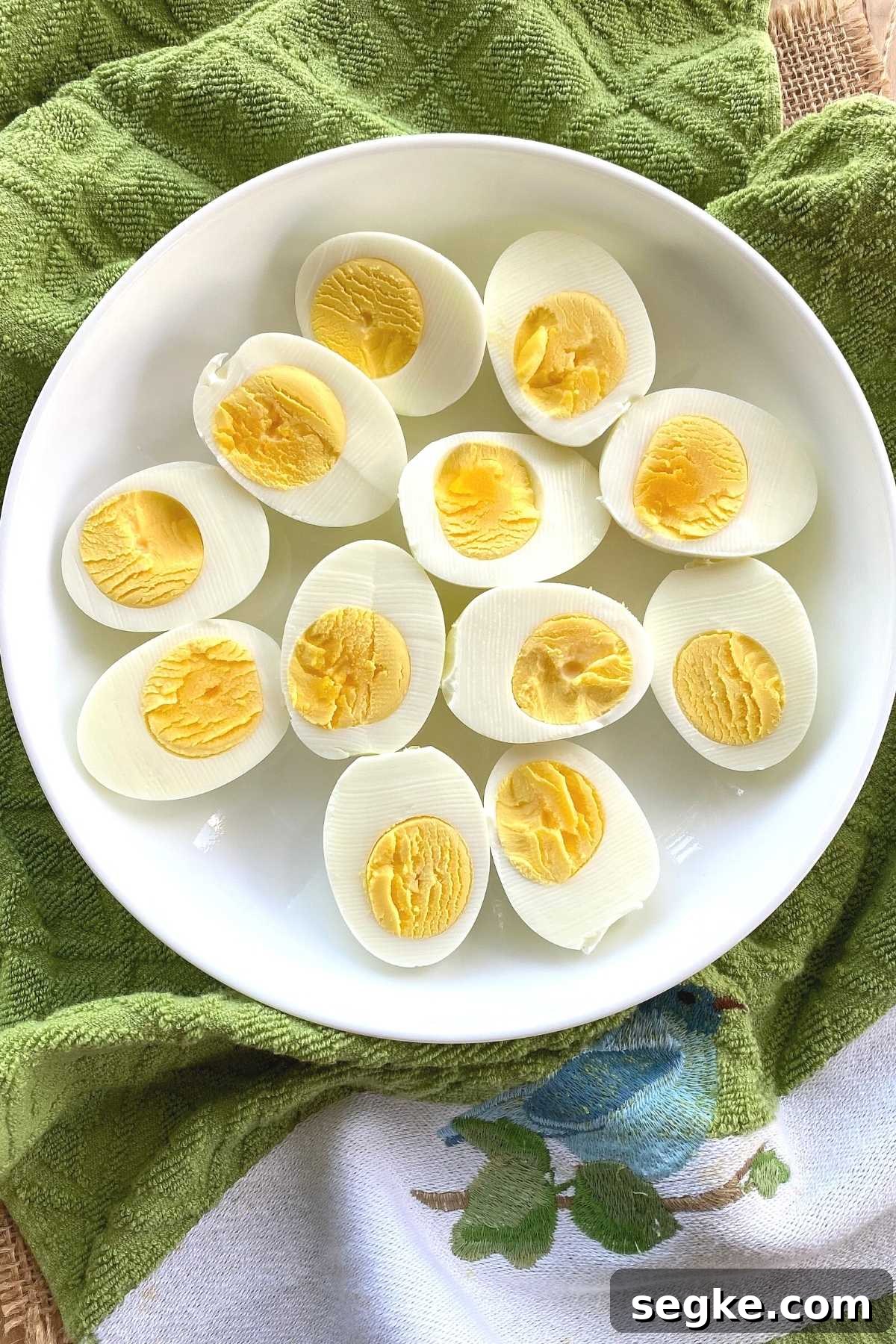 Plate of hard boiled egg halves on a towel.