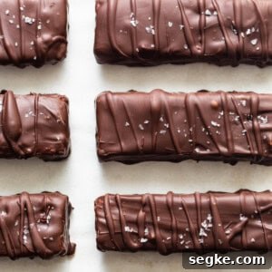A row of chocolate covered bars on a white surface.