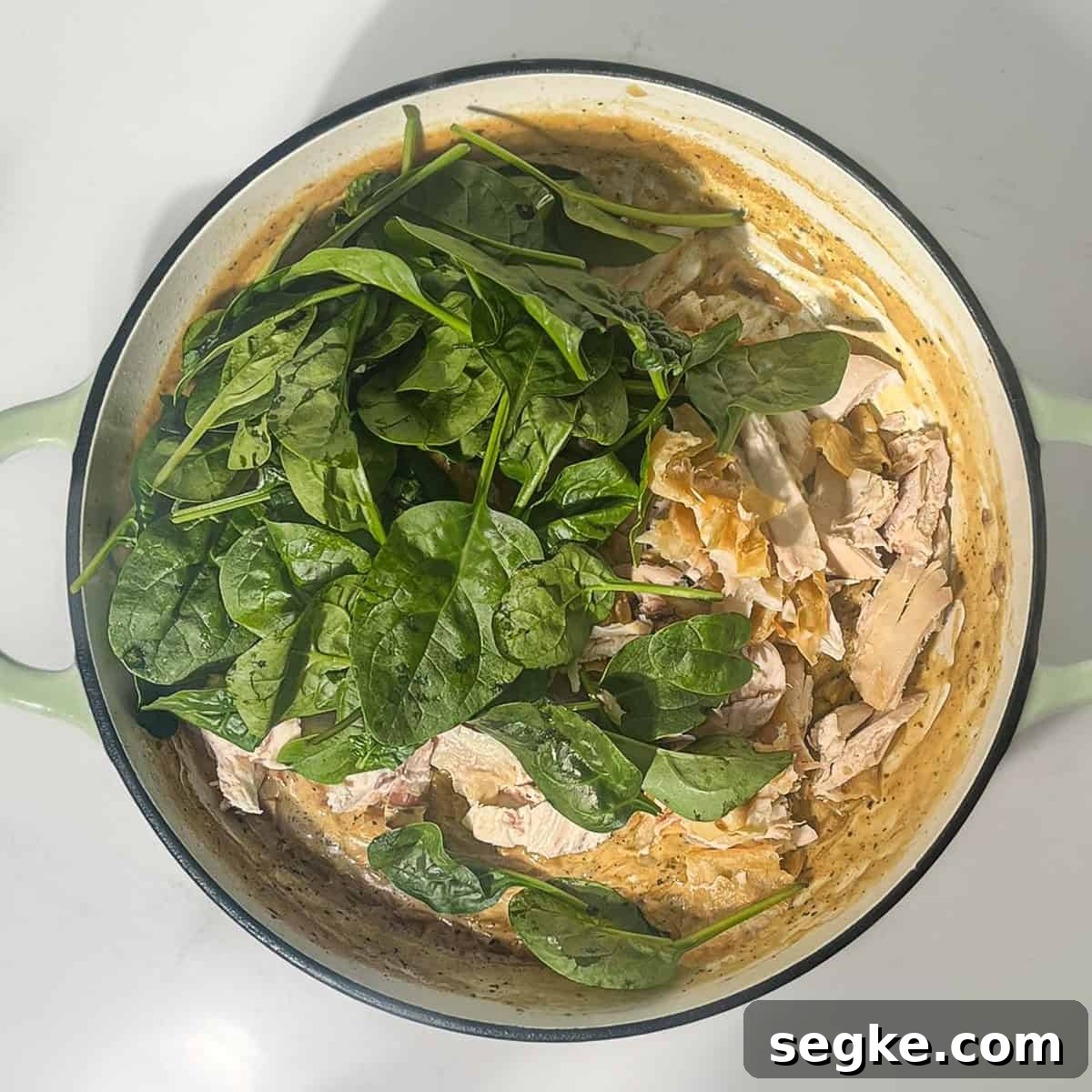 One-Pot Creamy Lemon Chicken Orzo 5 Adding spinach and parmesan to the lemon chicken orzo pasta in a large saucepan.