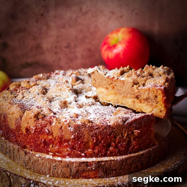 Using a cake server to serve a slice of French Apple Crumb Cake.