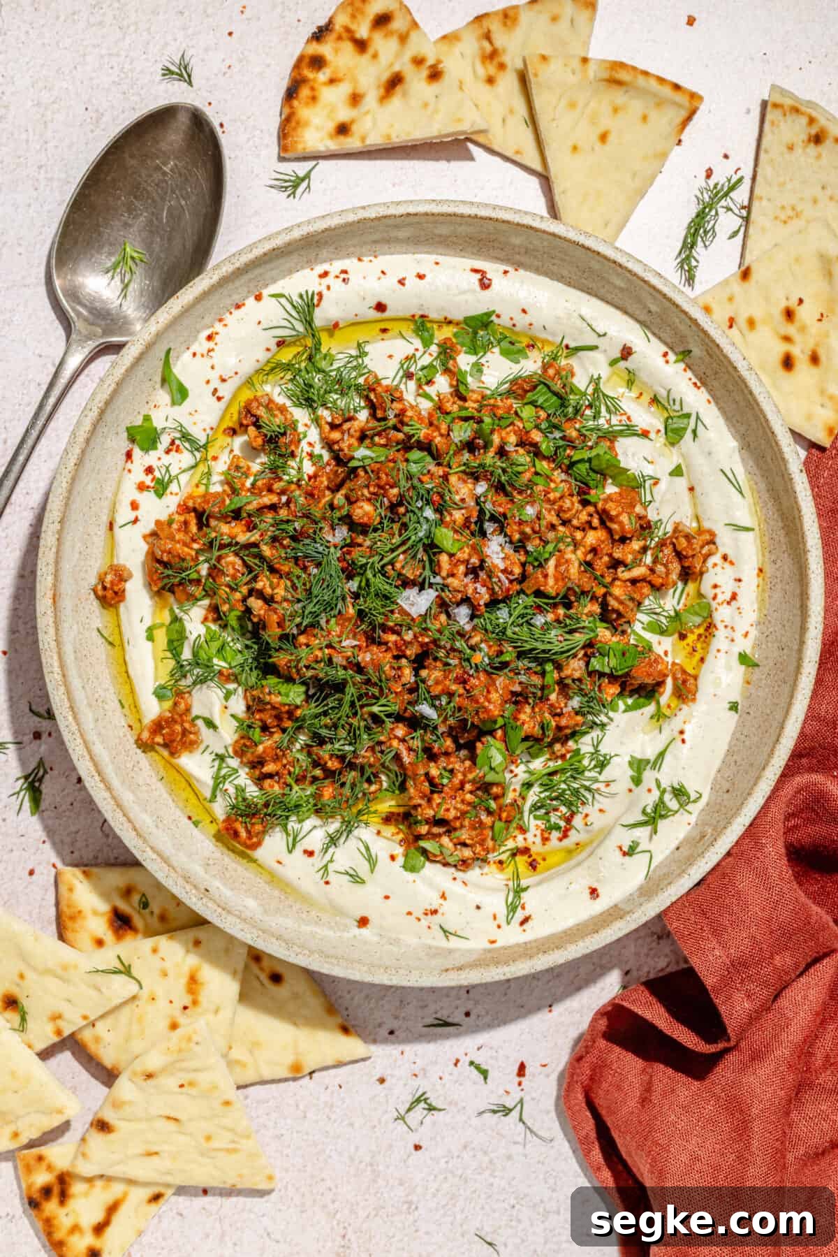 Labneh with Spicy Lamb and Roasted Eggplant Recipe 2 Spicy Lamb and Eggplant Labneh in a low bowl. Pita scattered around.