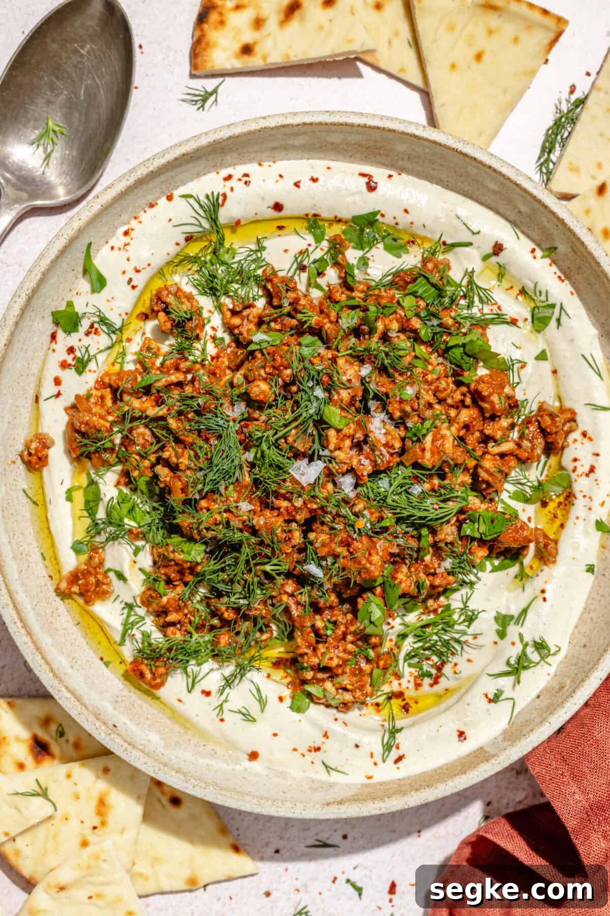 Labneh with Spicy Lamb and Roasted Eggplant Recipe 3 Spicy Lamb and Eggplant Labneh in a low bowl. Pita scattered around.