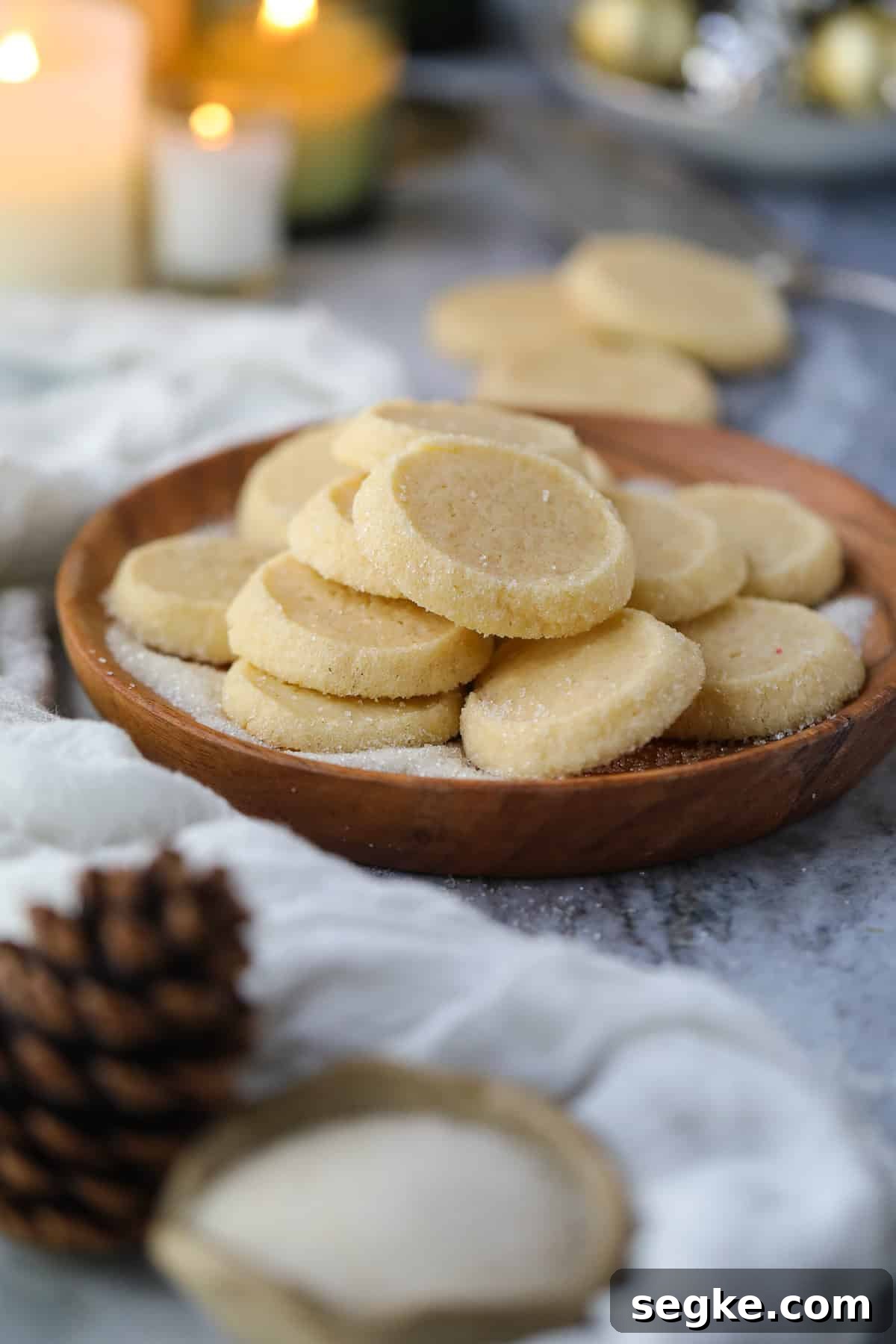 Cardamom butter cookies arranged on a wooden platter sitting on a table top.