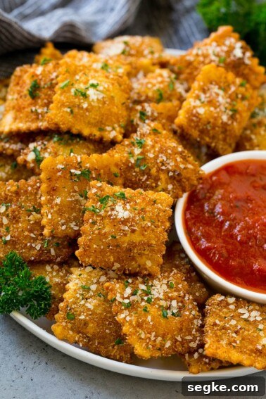 Baked Brie with Raspberries and Toasted Pecans Recipe 8 A plate of fried ravioli topped with parmesan and parsley, and served with a side of marinara sauce.