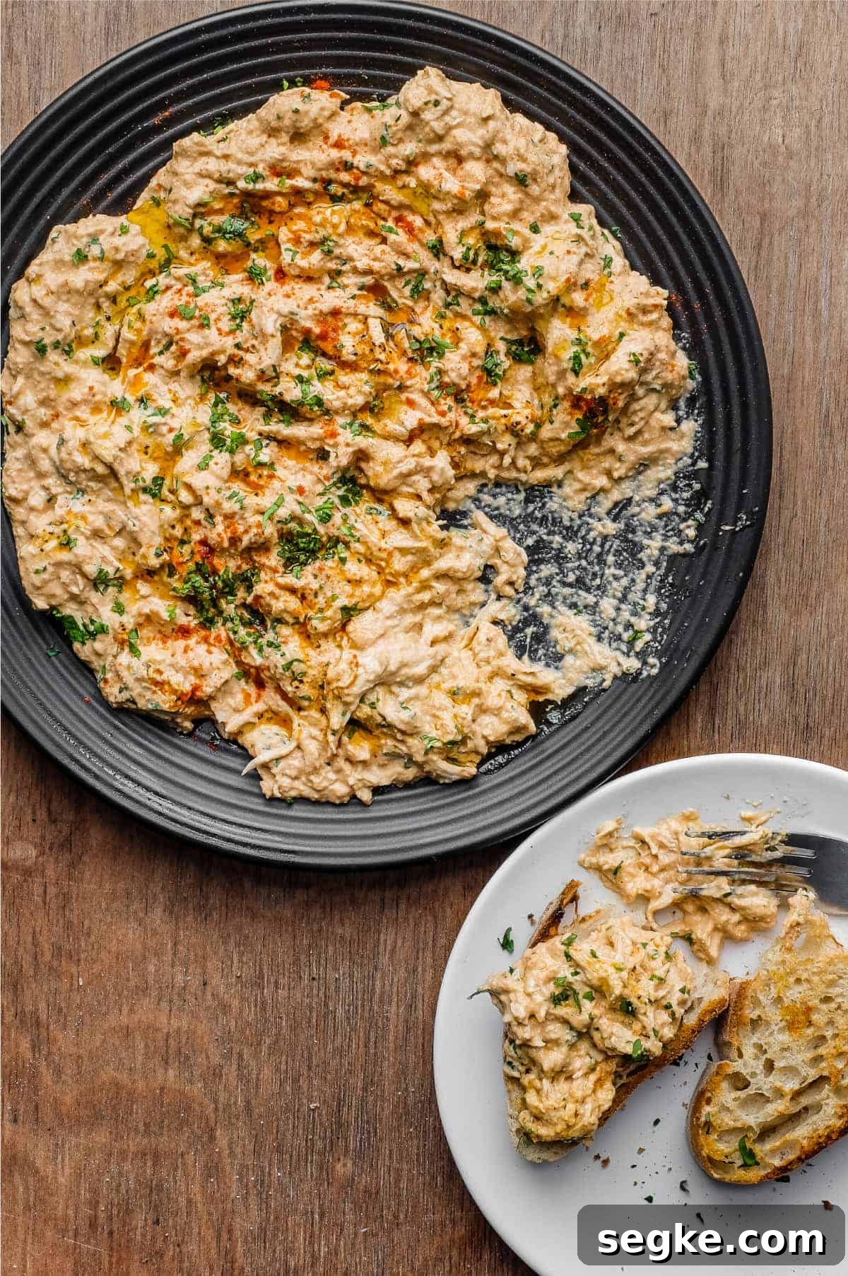 A plate of Turkish Circassian Chicken alongside two slices of crusty bread topped with the chicken
