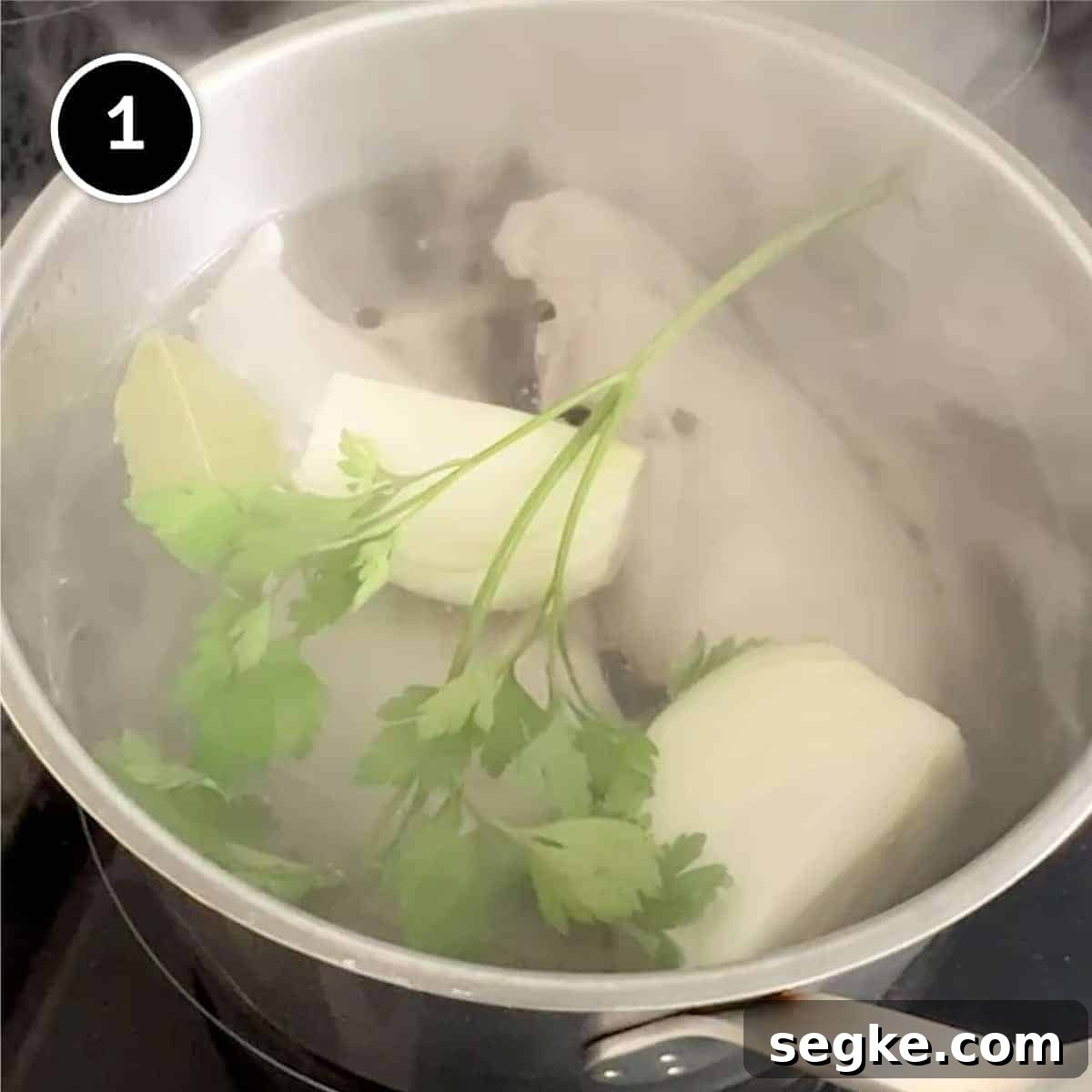 How to Make Authentic Circassian Chicken 2 poaching chicken breasts in a pan with onion, parsley, bay leaf and peppercorns