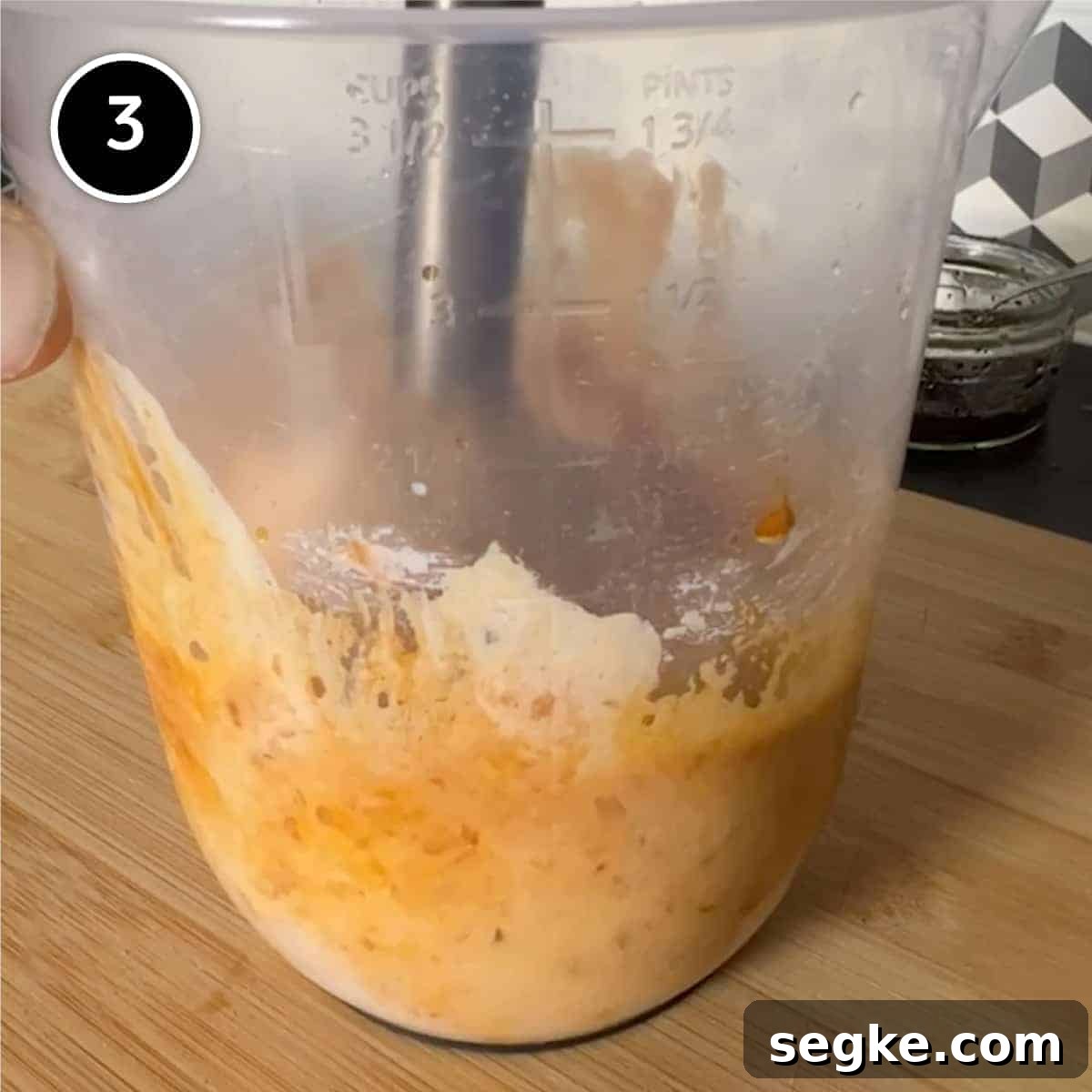 blending Circassian walnut sauce with a stick blender in a plastic jug