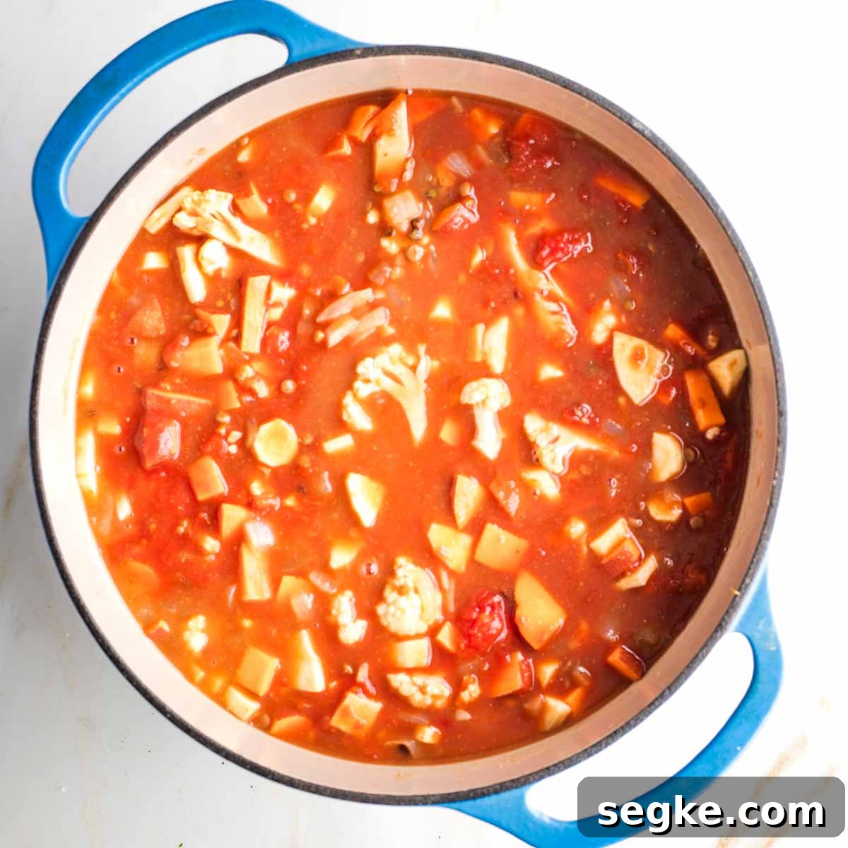 Crushed tomatoes diluted with veggie broth, cooking chopped veggies in a dutch oven.