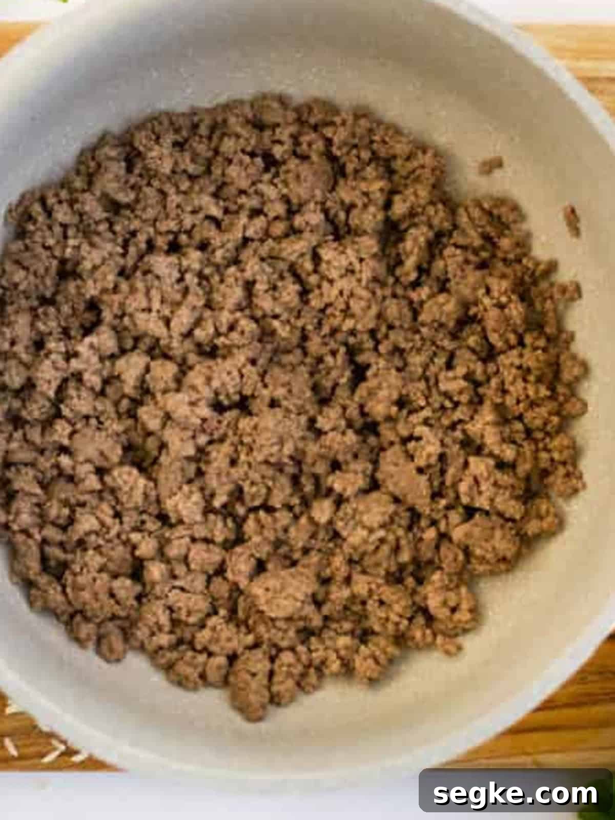 Browned ground beef in a Dutch oven for stuffed pepper soup.