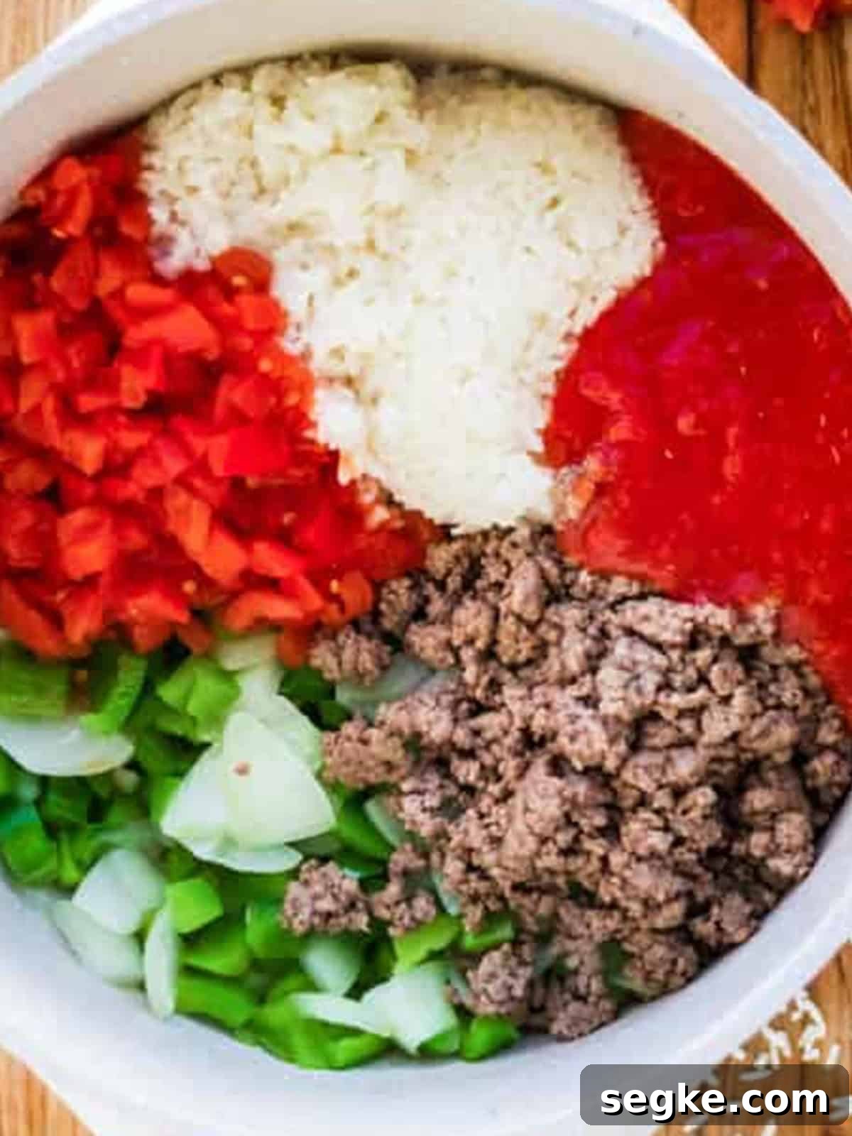 Ground beef, rice, diced red peppers, tomatoes, green peppers, and onion added to the pot for stuffed pepper soup.