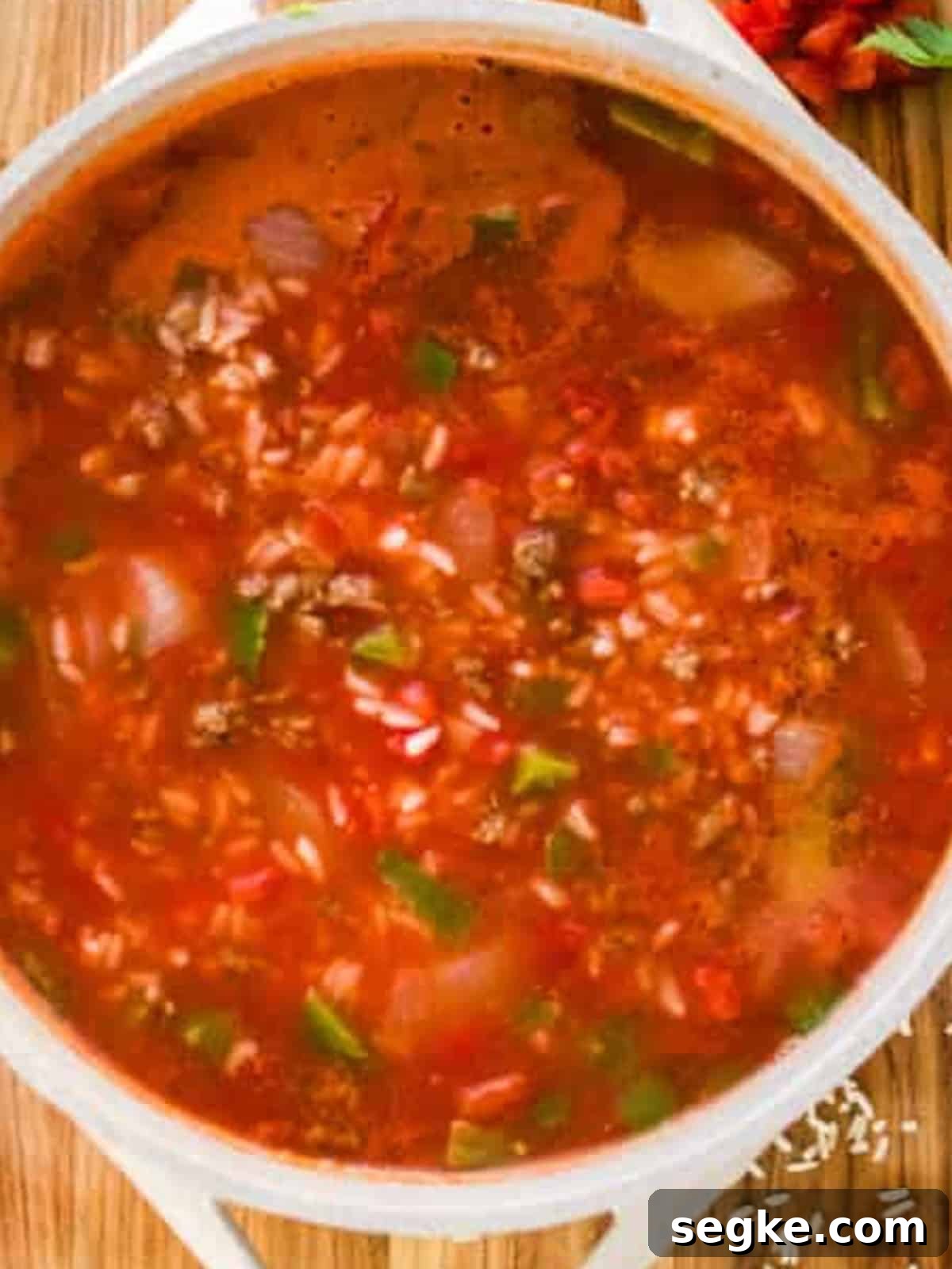 Finished stuffed pepper soup simmering in a pot with beef, rice, peppers, and tomato broth.