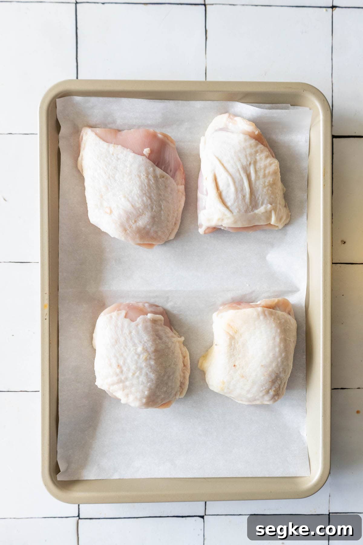 Crispy Oven-Baked Ranch Chicken Thighs 6 Raw chicken thighs on a baking sheet