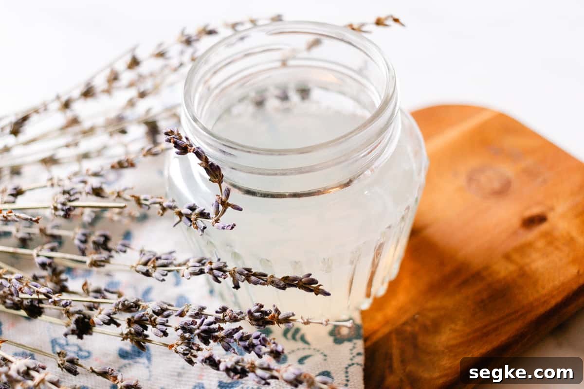 DIY 2-Ingredient Hair Gel You Can Make at Home 7 DIY hair gel with lavender springs on a wooden tray.