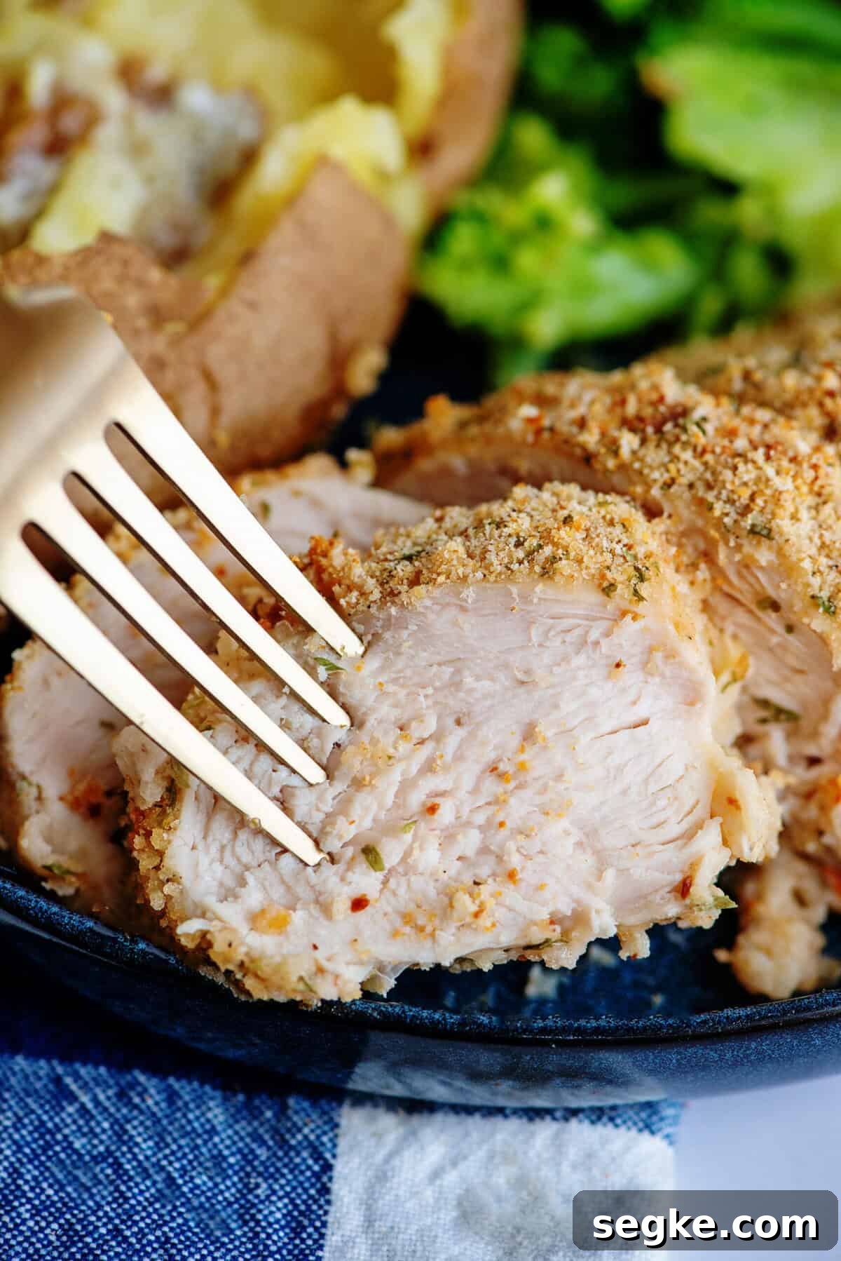 Close-up of juicy oven fried chicken with a fork.