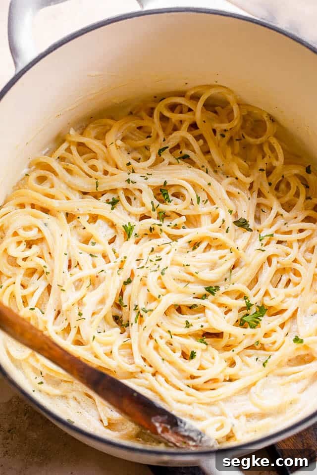 top shot of cream cheese spaghetti in a white pot