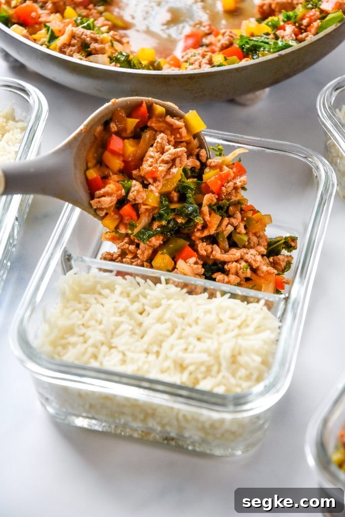 scooping chipotle ground turkey skillet mixture into meal prep container