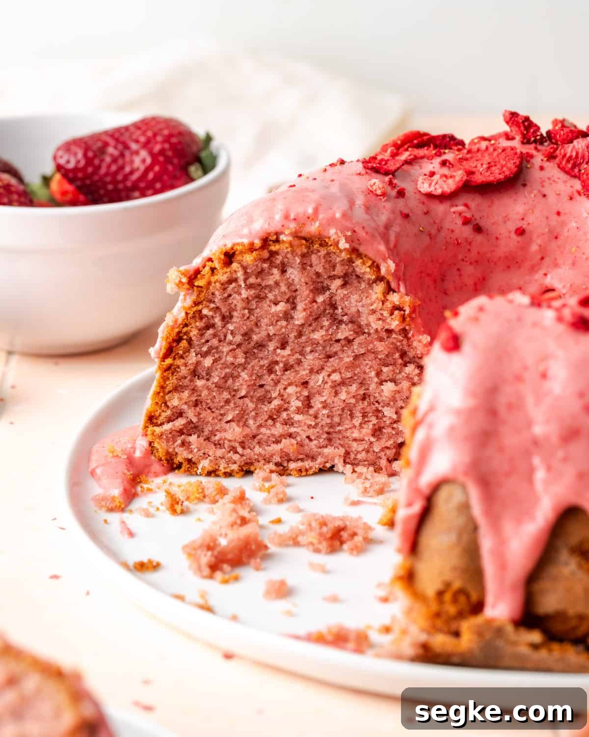 A strawberry pound cake sliced so the pink interior is showing. 