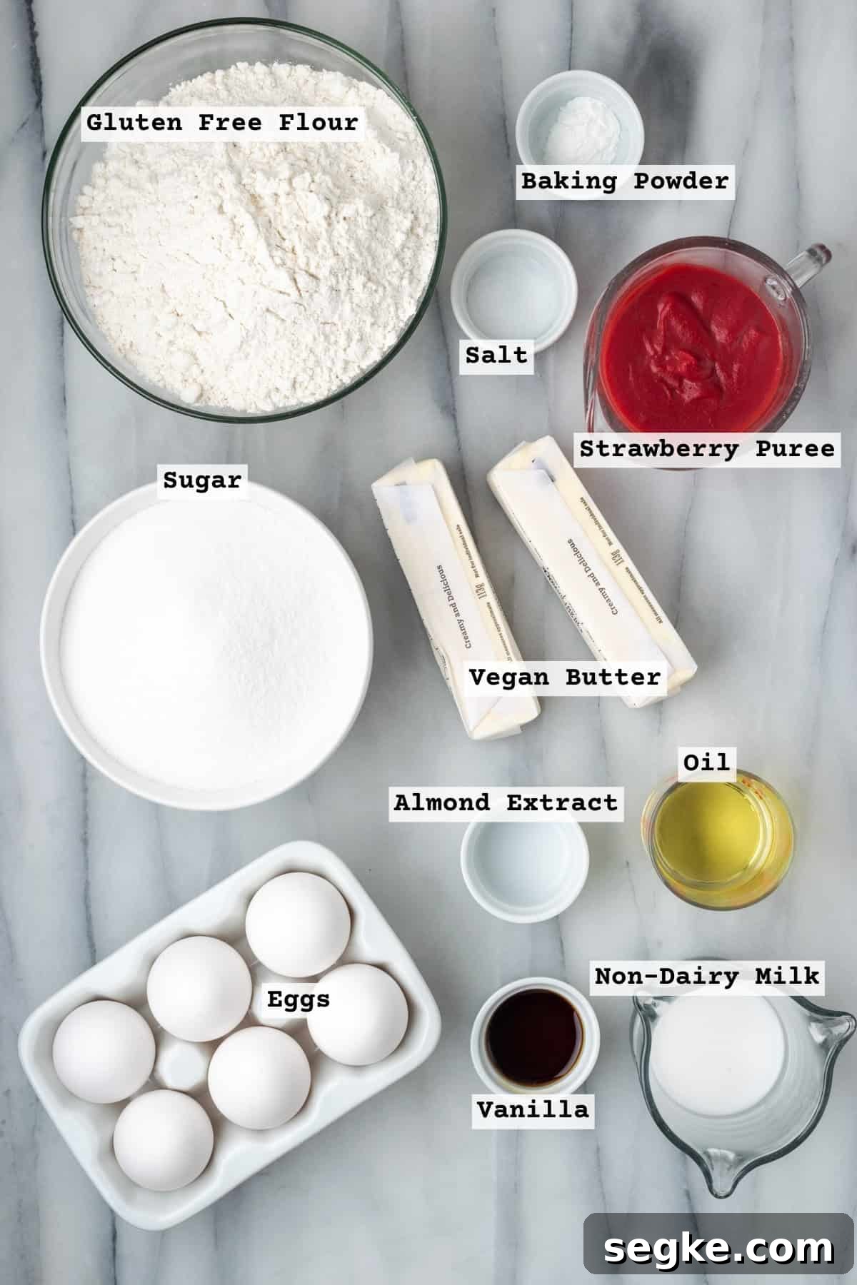 Ingredients for strawberry pound cake on a white table. 