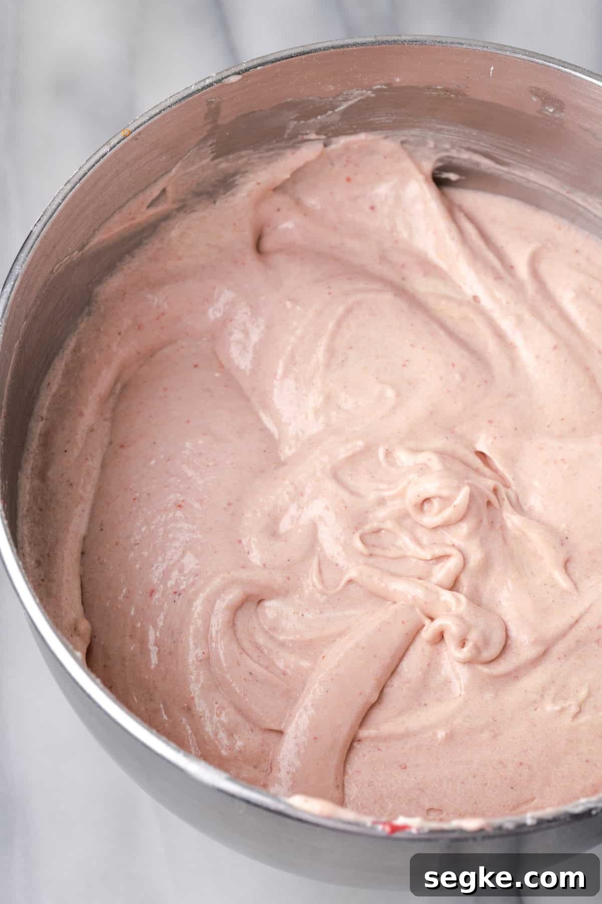 Strawberry pound cake batter in a large metal mixing bowl.