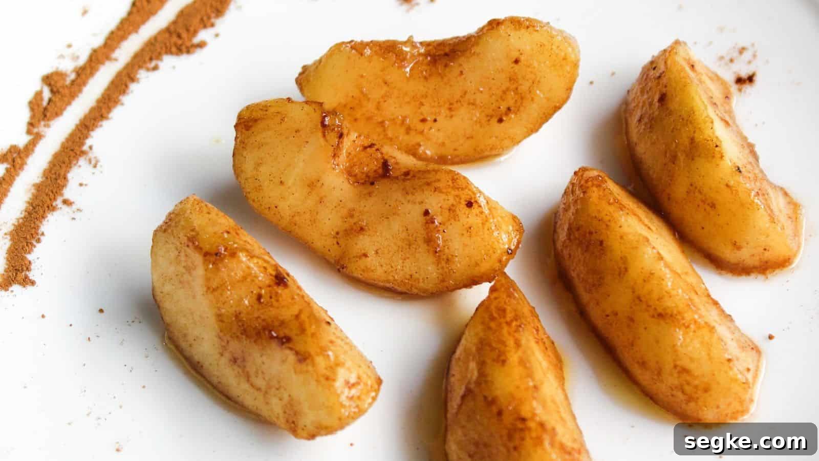 Cinnamon apple slices on a white plate.