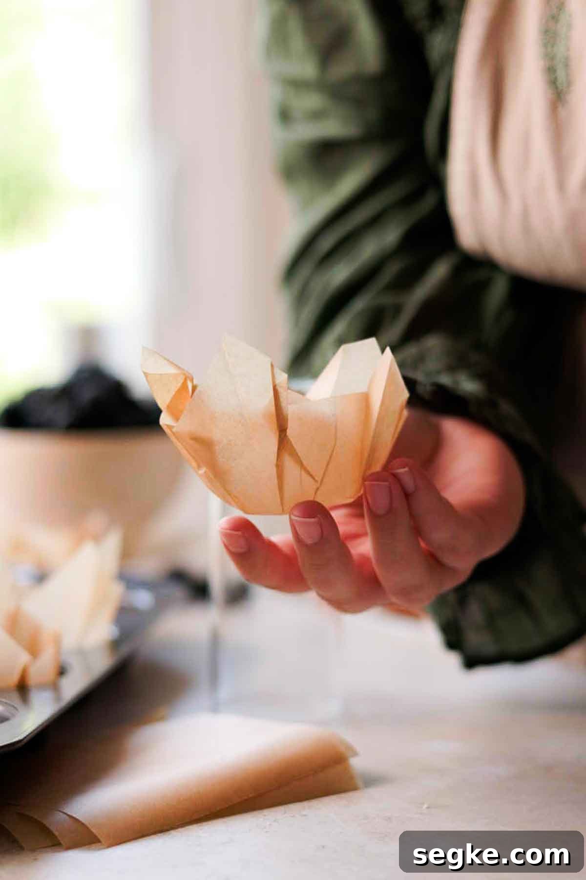 Blackberry Muffins Recipe: Fluffy, Juicy, Homemade 14 holding diy parchment paper liner in hand