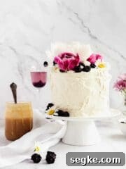 decorated cake with peonies and blackberries