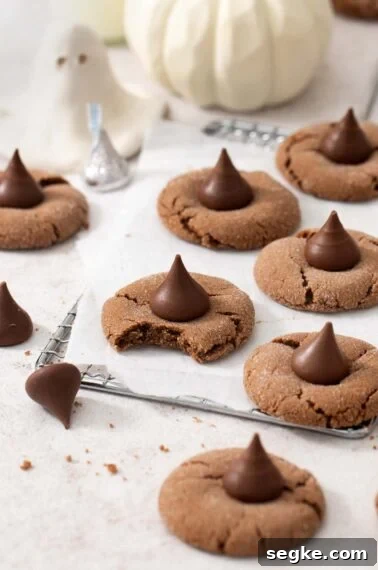 Gluten-free Nutella witch hat cookies on a wire cooling rack. One cookie has a bite taken out of it.