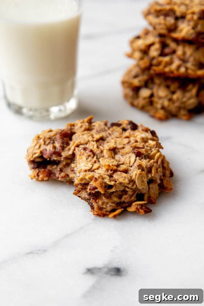 Banana Oat Breakfast Cookies - Gluten-Free Vegan 7 Close up of a banana breakfast cookie on a counter with a glass of milk alongside.