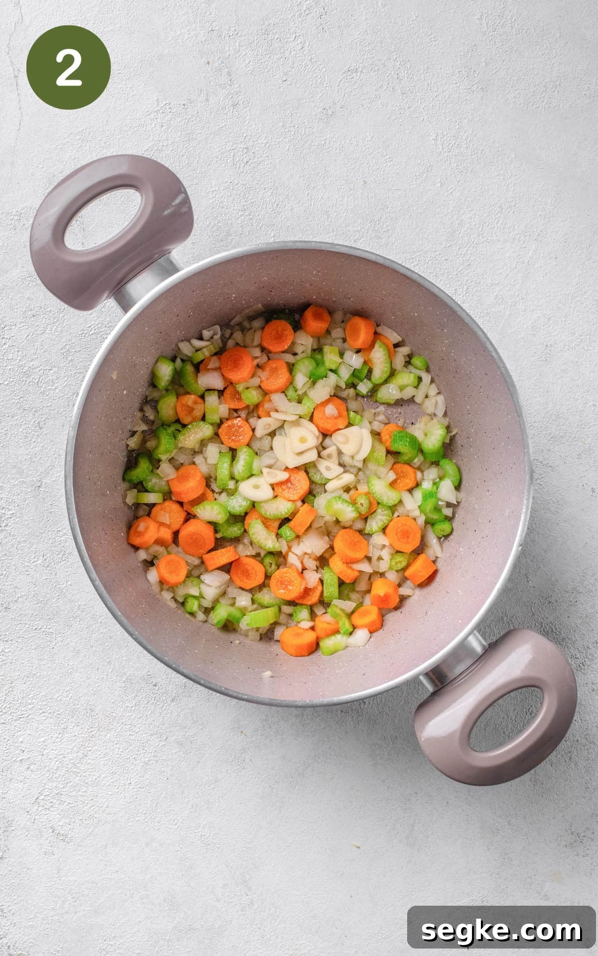 onion, carrots, and celery in a pot.
