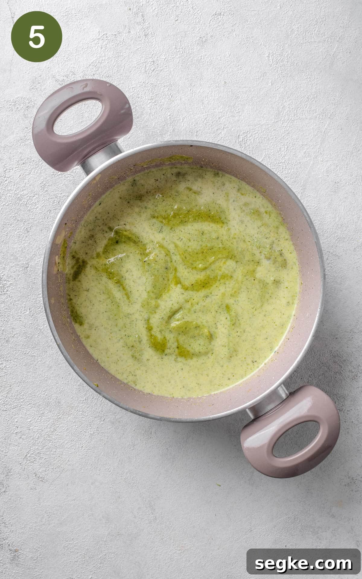 green soup in a pot with cooking cream.