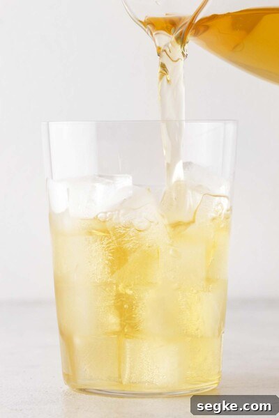 Refreshing Chamomile Iced Tea with Honey and Lemon 7 Pouring tea into a cup with ice.