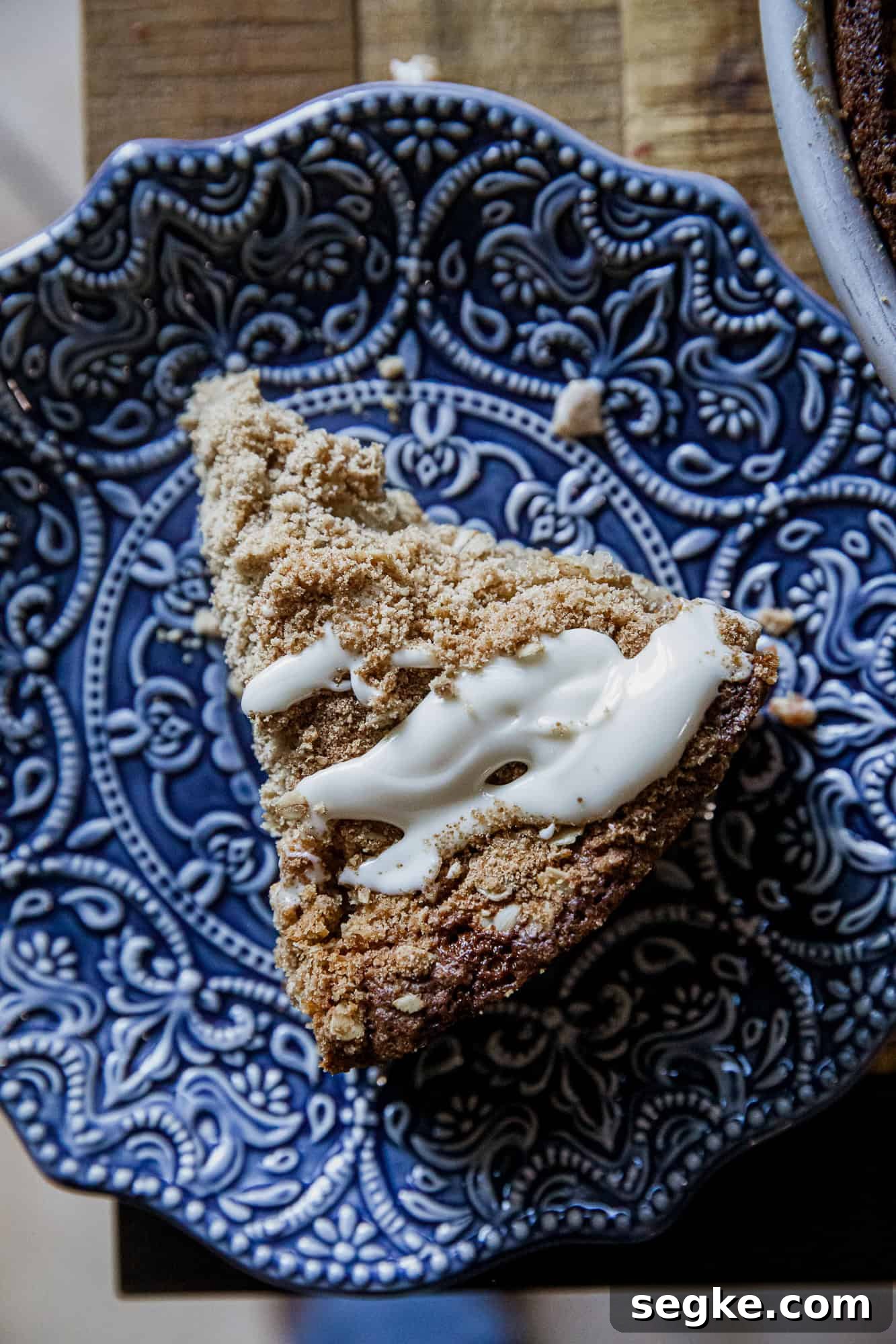 Delicious banana crumb cake with crunchy topping on a decorative blue plate. Perfect for breakfast.