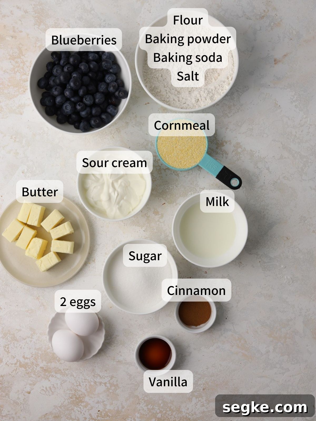 Moist Blueberry Cornmeal Cake Recipe 2 Labeled ingredients needed to make blueberry cornmeal cake laid out on a table.