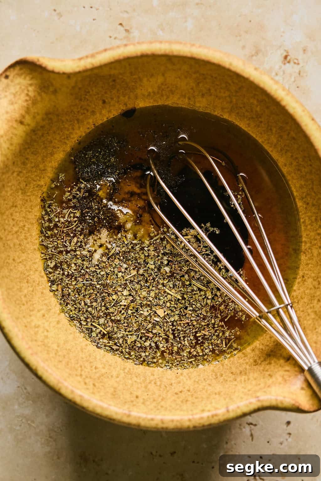 Whisk in bowl with sun dried tomato dressing.
