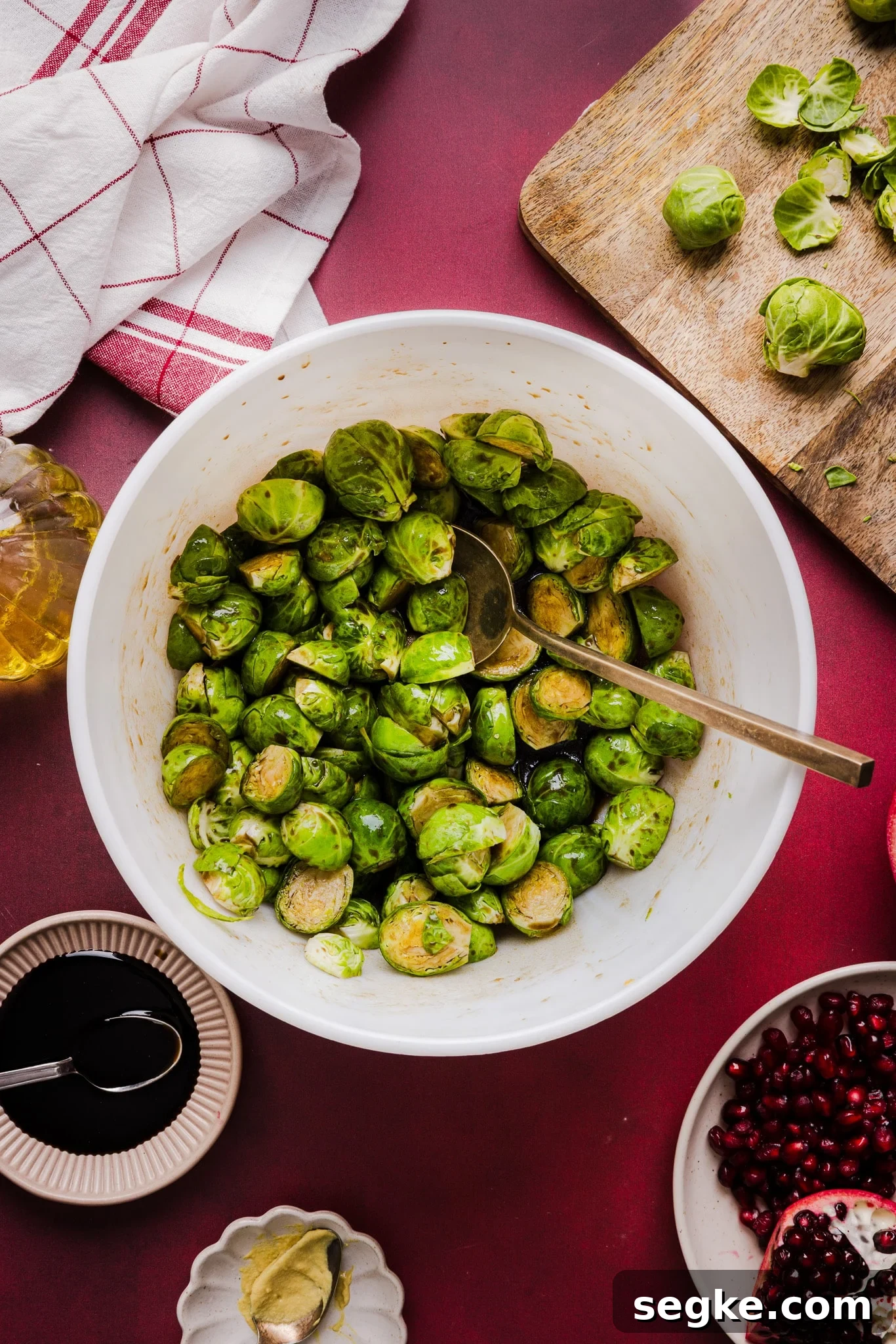 Brussels sprouts being tossed in a maple balsamic dressing.