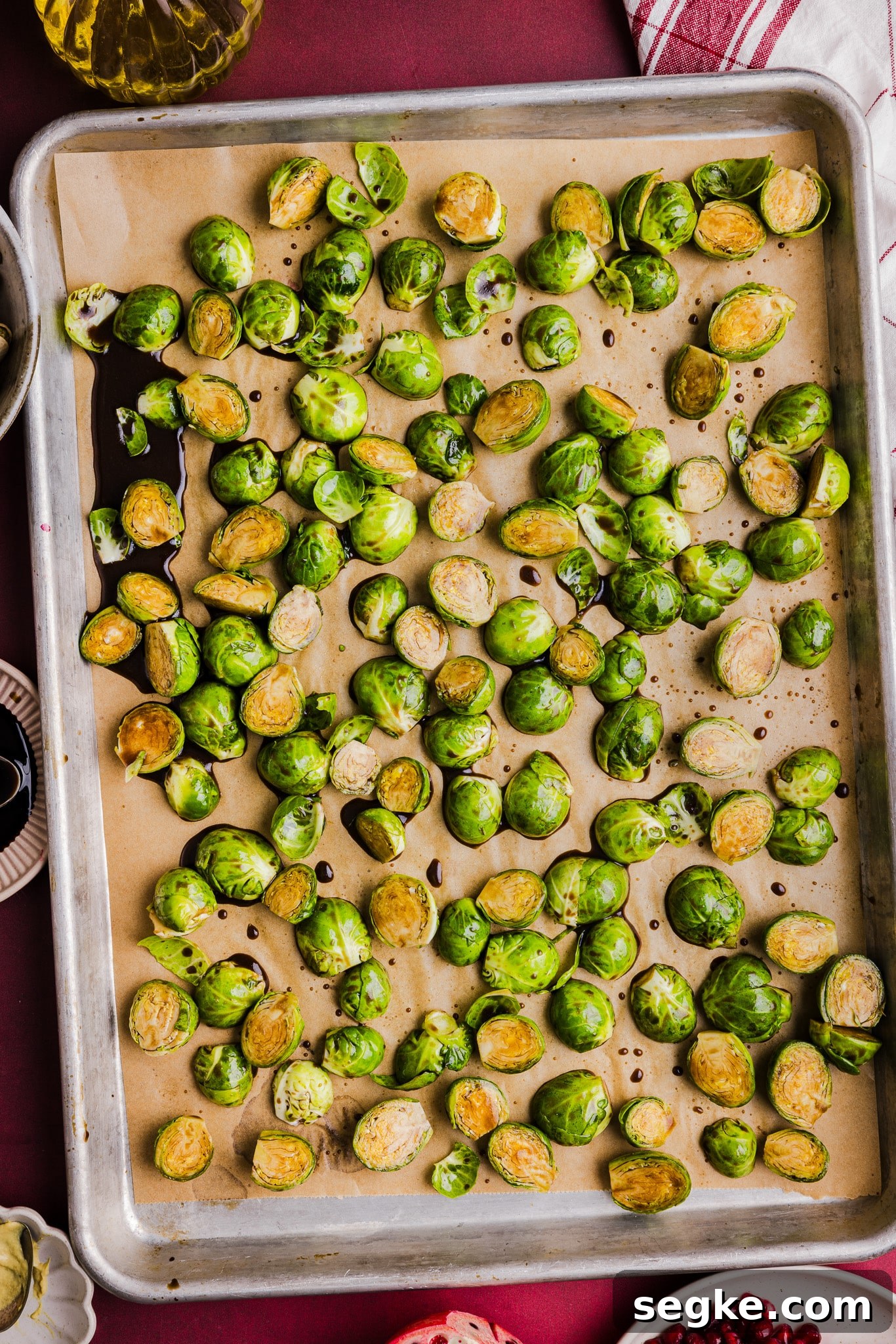 Maple balsamic brussels sprouts on a sheet pan ready to be roasted.