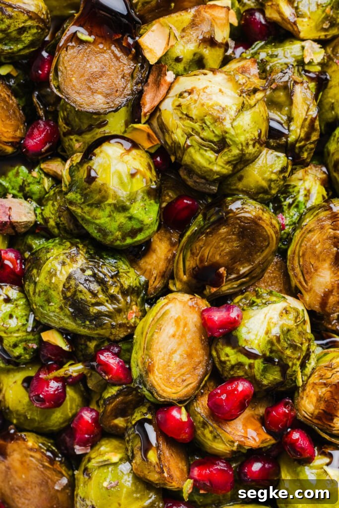 Roasted maple balsamic brussels sprouts topped with pomegranate seeds and pistachios.