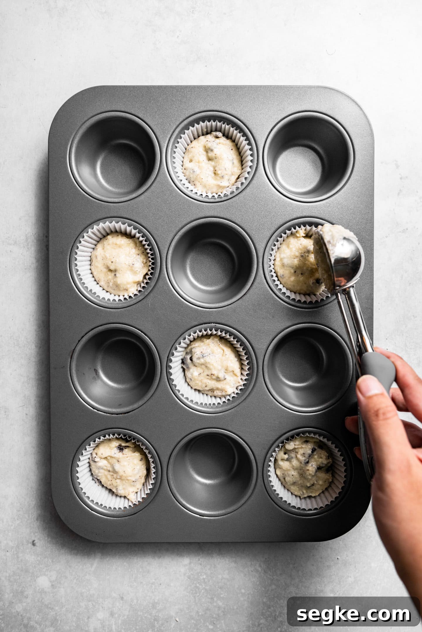 Oreo Cupcakes with Whipped Oreo Cream Frosting 8 Oreo cupcake batter being portioned out into prepared cupcake pan.