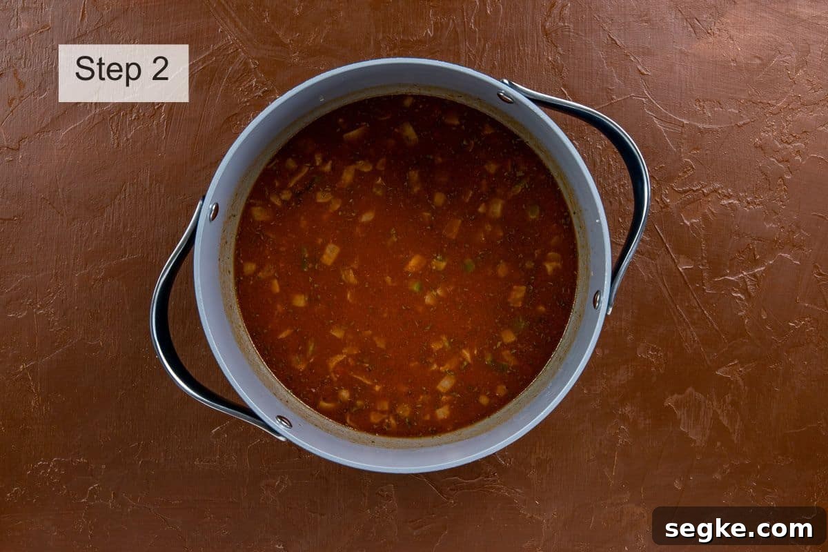 Tomato sauce, seasonings, and hot water added to beef and rice mixture.