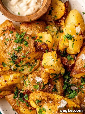 Smashed yellow potatoes topped with chopped parsley.