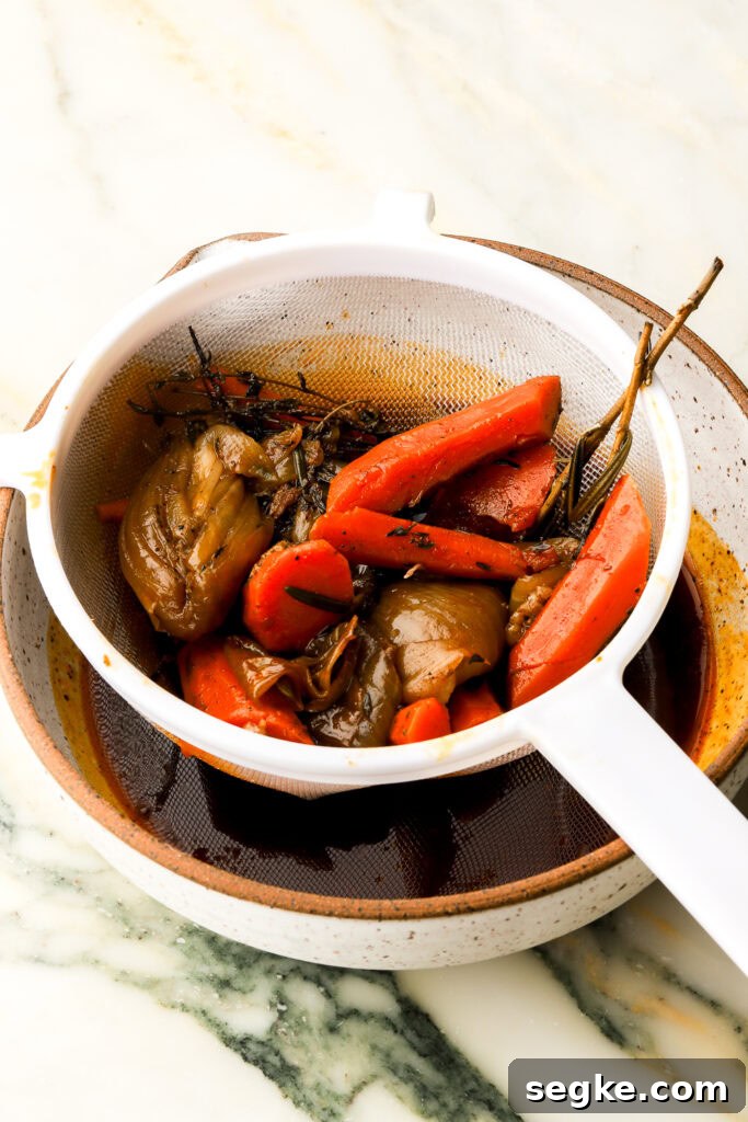 Everyday Braised Beef Recipe for Weeknight Dinners 10 broth getting strained into a large bowl or measuring cup